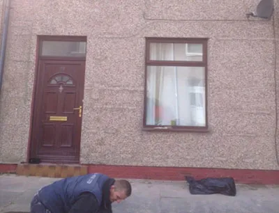 A man kneeling down in front of a building.