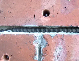 A close up of a brick wall with holes in it.